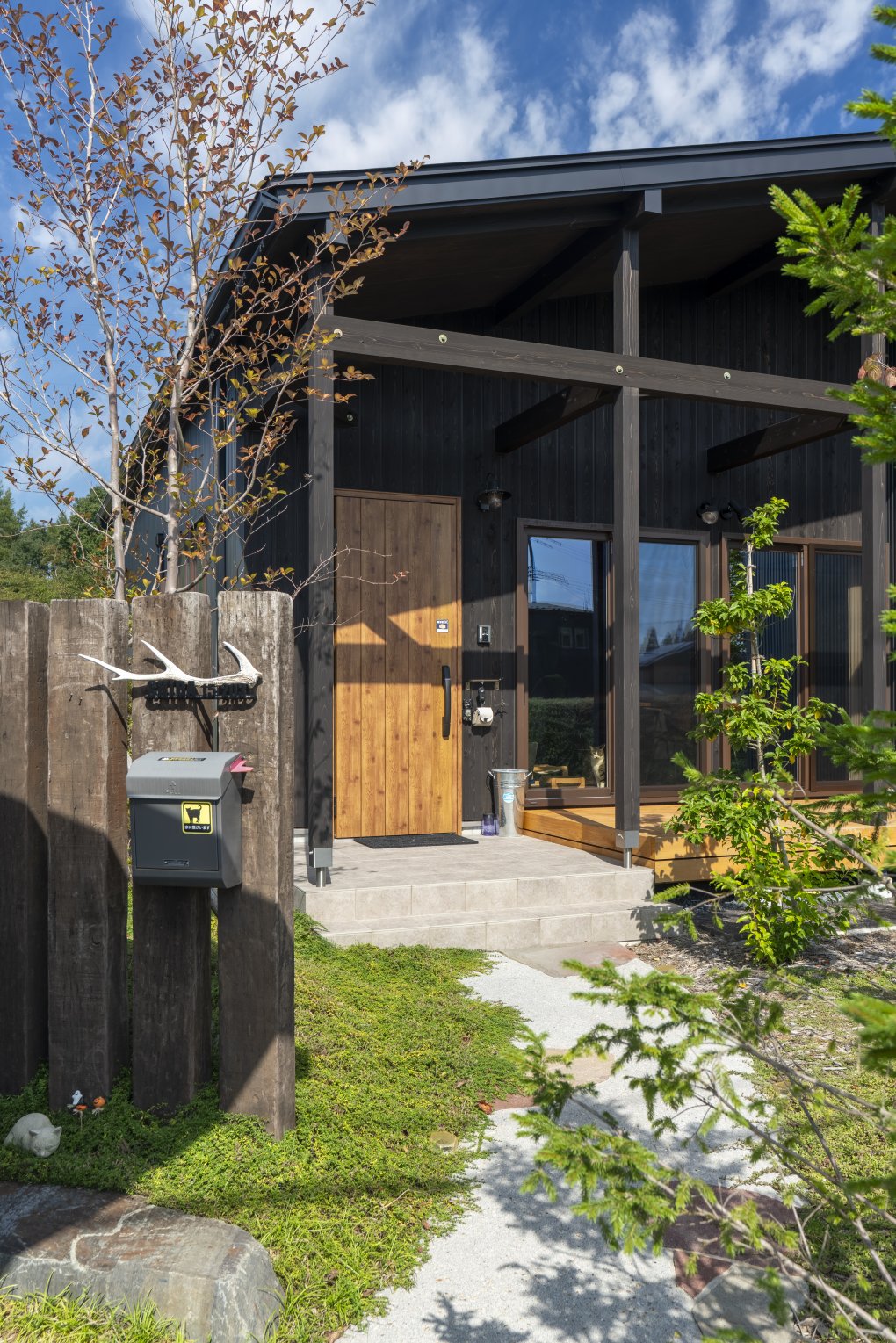 庭の専門店を紹介してもらい、お願いしたというエントランス。 バランス良く配された植栽が季節ごとに住まいを彩る。  枕木や動物のモチーフを飾った自然と調和したアプローチが家族を迎えてくれる。